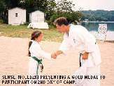 Sensei Moledzki presenting a gold medal to a student on the 2nd day of Camp.